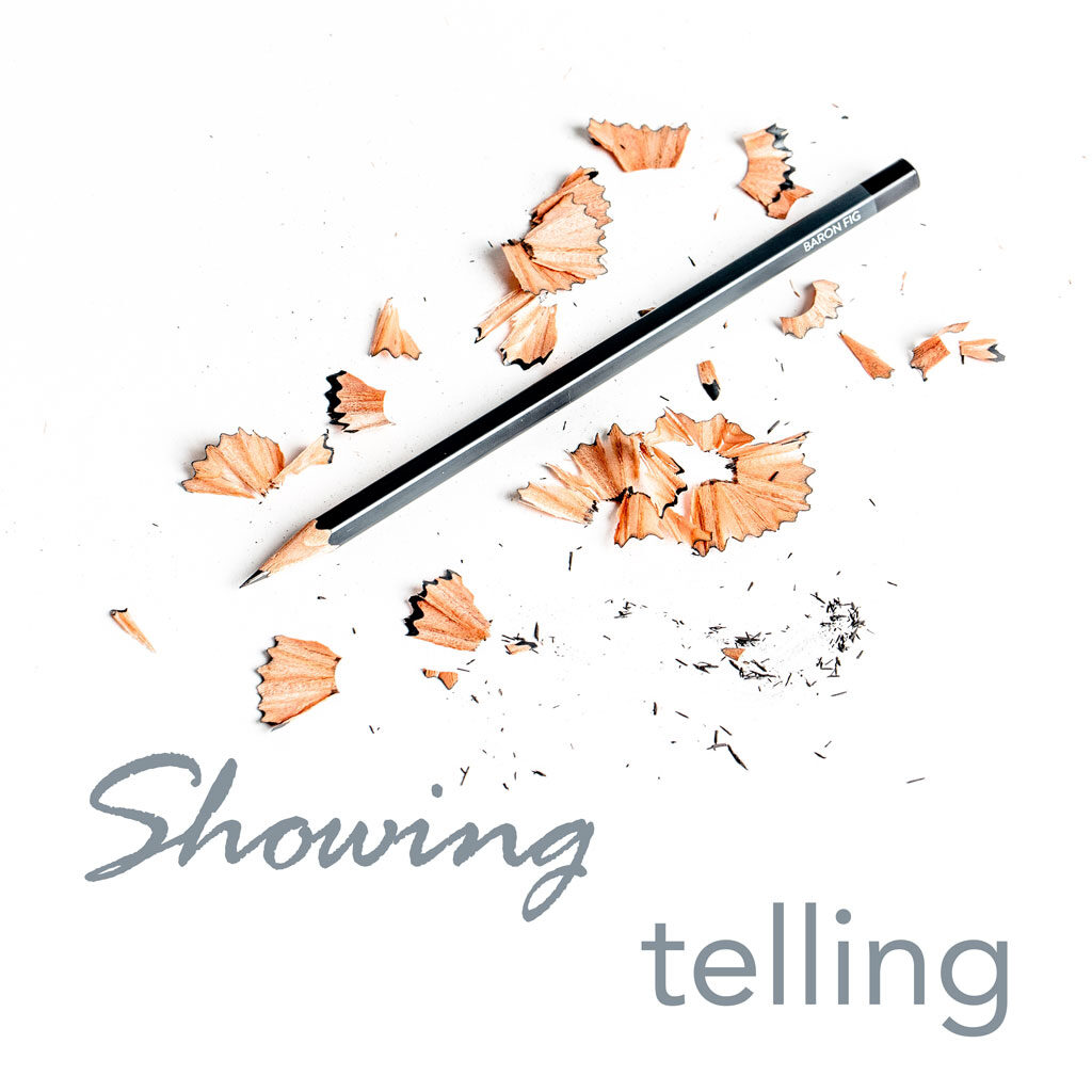 sharpened pencil lying amidst pencil shavings and text saying 'showing' and 'telling' on white background