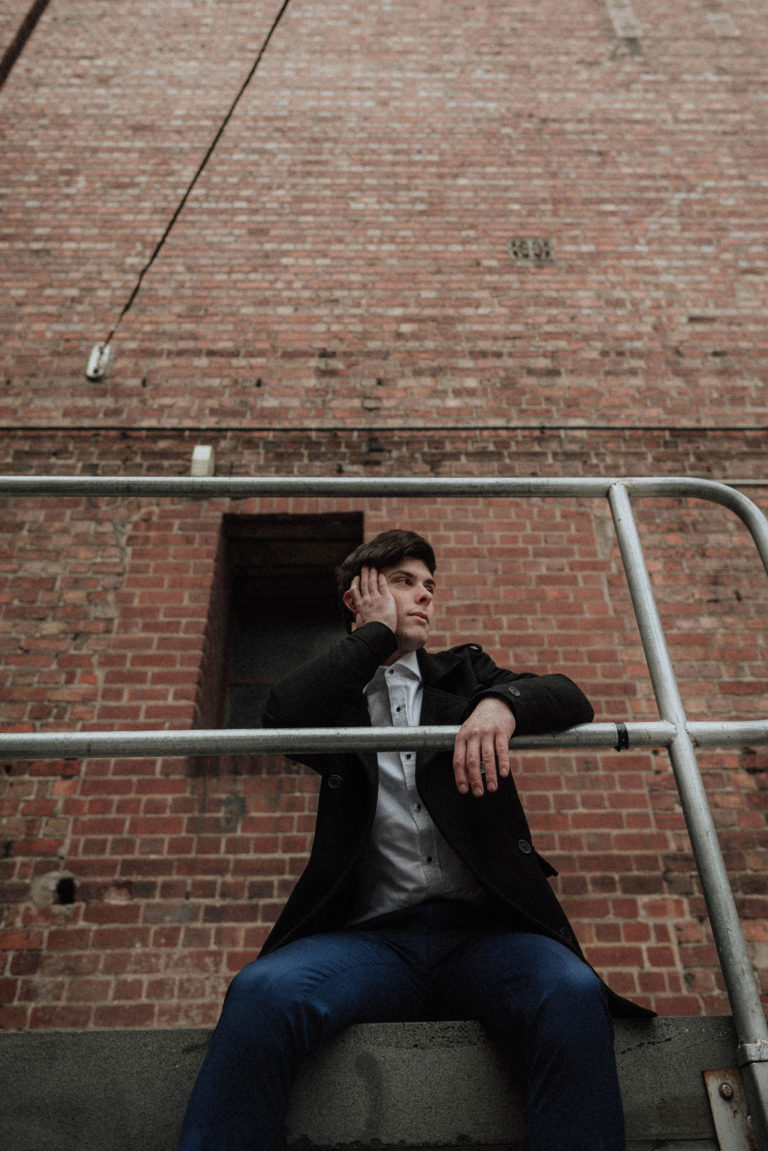 Young man with an arrogant expression on a fire escape
