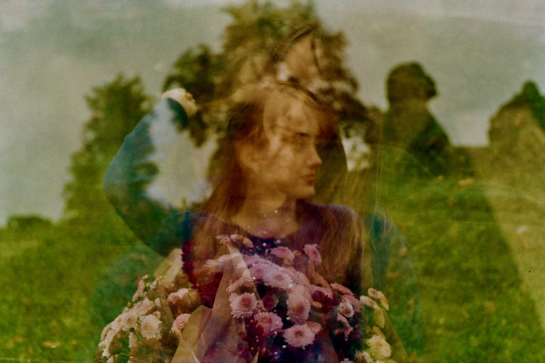 multiple exposure image of a woman against an outdoor background with a silhouette image and flowers