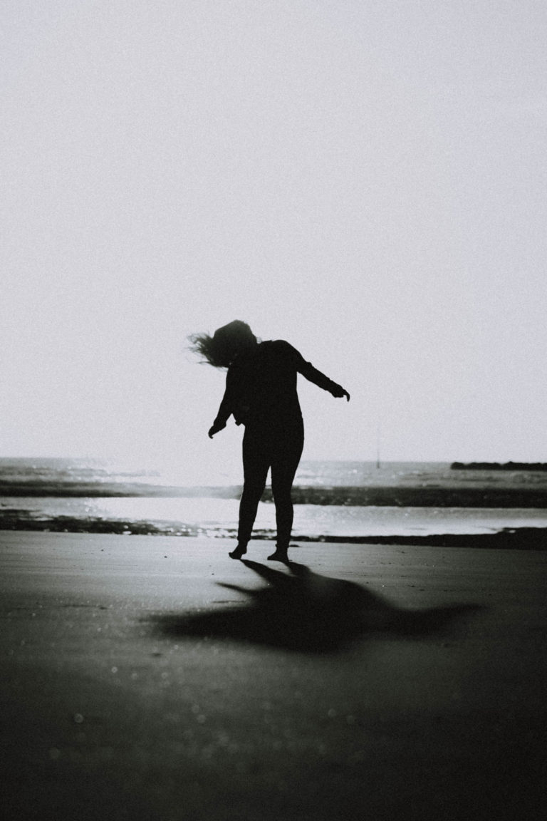 black and white image of a girl on the beach