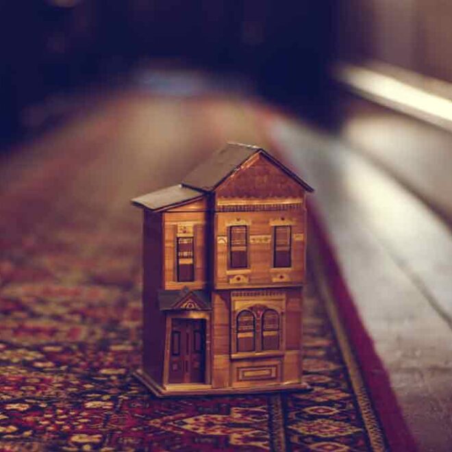 Miniature two-story house on patterned rug