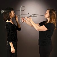 two women playing a glass trumpet